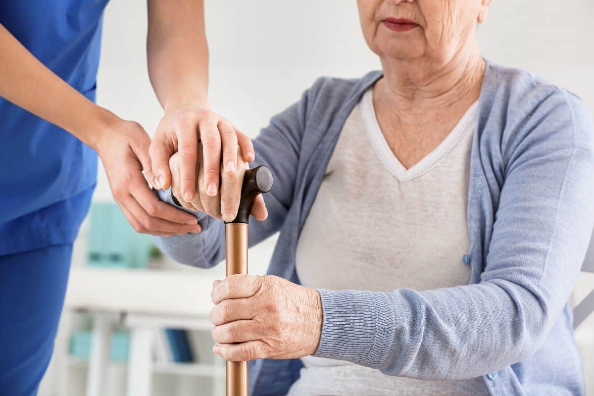 bengala na mão da idosa com Parkinson