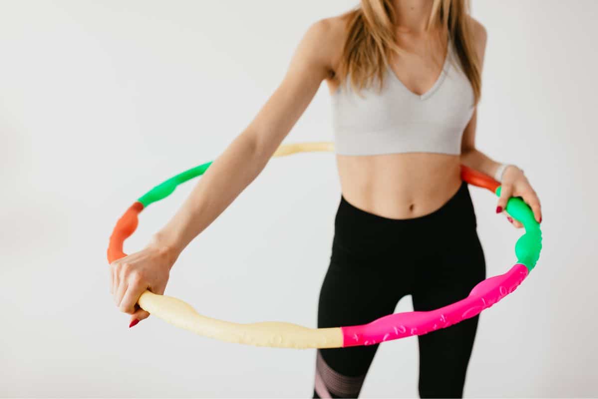 É verdade que bambolê afina a cintura? Faça o teste e perca muitas calorias 1 mulher usando bambolê
