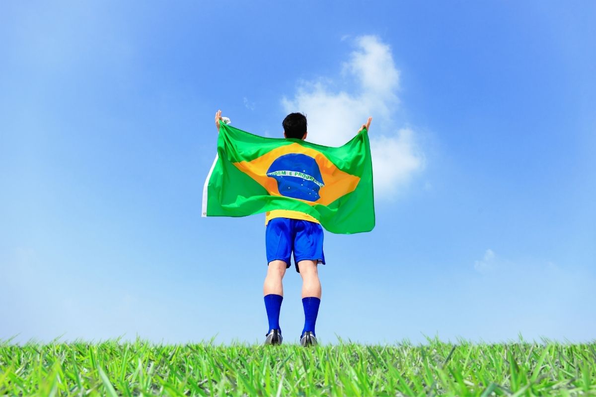 bandeira do brasil erguida nas costas do jogador de futebol