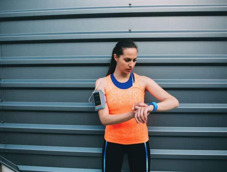 Como escolher o melhor horário para praticar atividades físicas? Dicas de Especialista 7 mulher conferindo hora para treinar