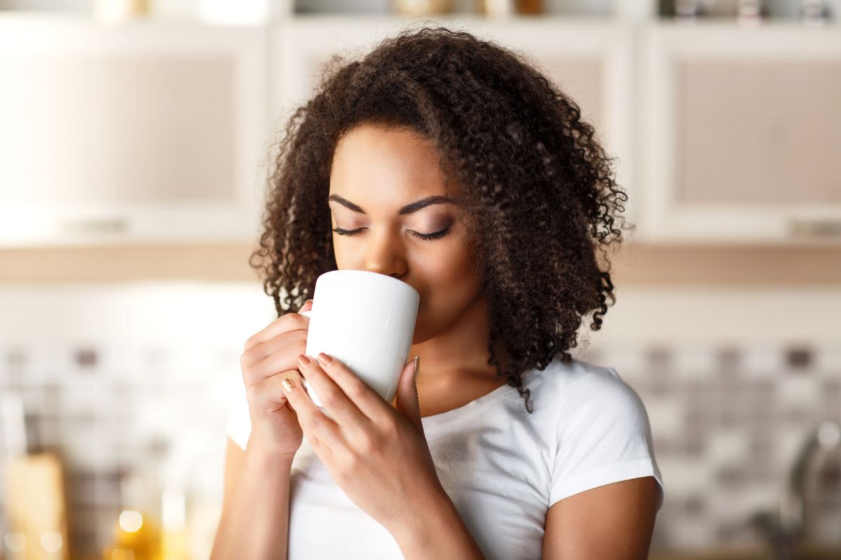 Chá para infecção urinária: 5 opções para alívio natural e eficaz para os sintomas 1 Mulher negra tomando chá.