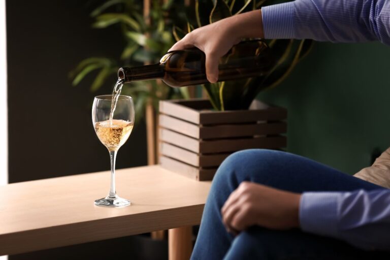 Álcool e coração: por que sua frequência cardíaca aumenta durante o sono 5 pessoa adicionando vinho branco a uma taça.