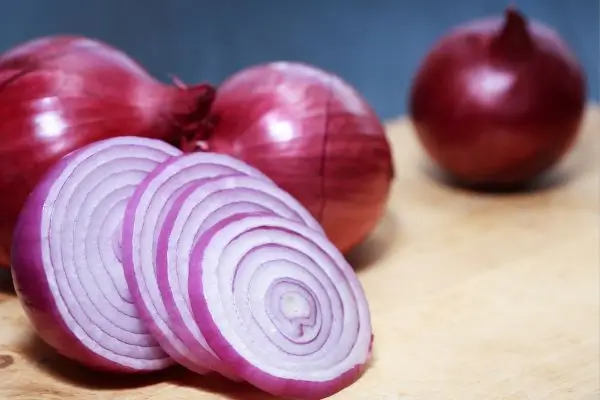 Chá de cebola roxa: para que serve, como fazer e benefícios comprovados 2 cebola roxa cortada inteira e cortada em fatias.