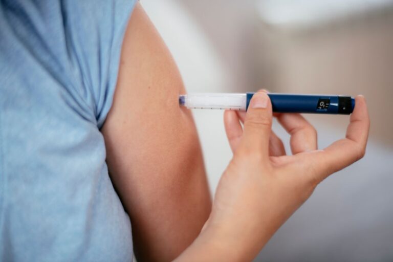 mulher aplicando insulina em caneta no próprio braço.