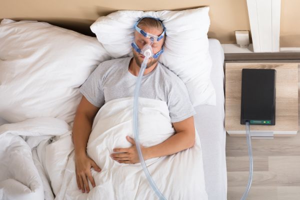 Sintomas de apneia do sono: como identificar e quando buscar ajuda médica 2 homem usando CPAP.